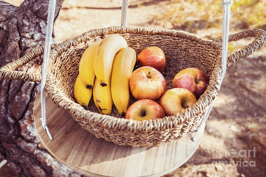 A wicker basket full of fruits in a natural picnic setting. Photograph by Joaquin Corbalan