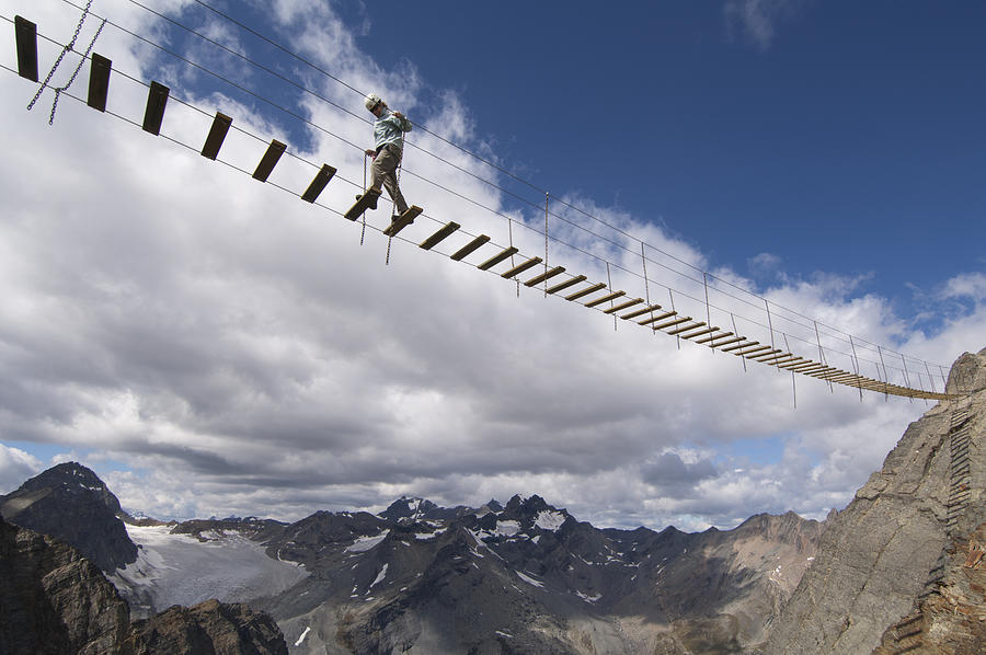 A woman crosses an exposed suspension bridge. Photograph by Topher Donahue
