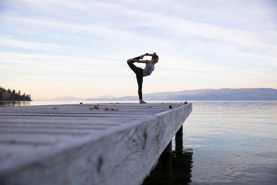 A woman doing yoga on a dock Photograph by Jordan Siemens
