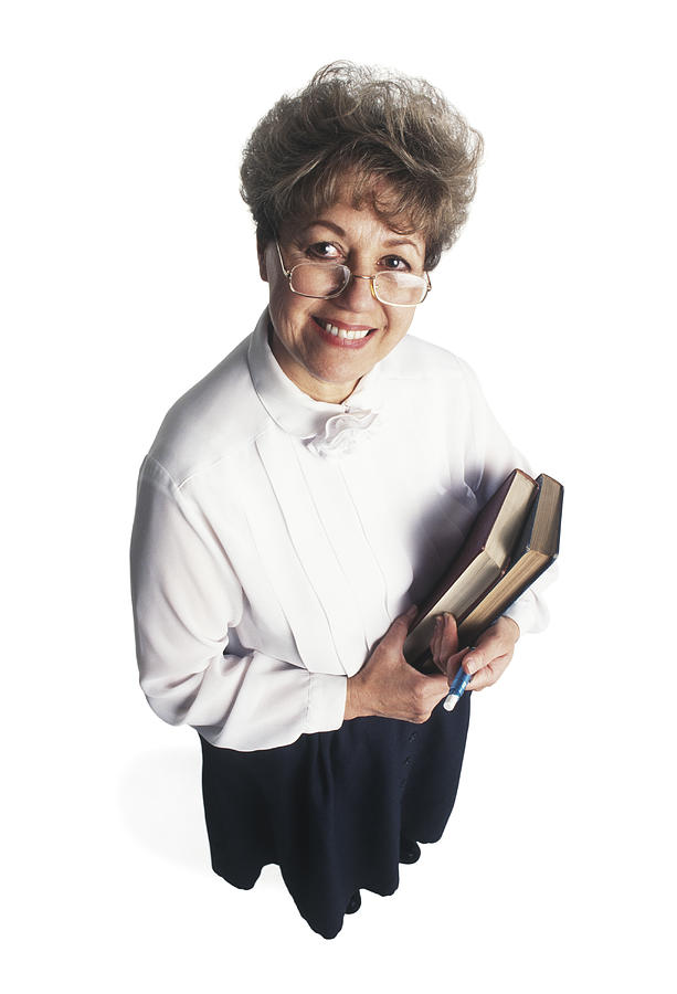A Woman Dressed In A Black Dress And White Shirt Holds Books As She Looks Up Toward The Camera Photograph by Photodisc