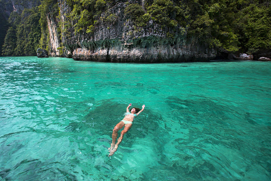 A woman floating on her back in tropical water. Photograph by Jordan Siemens