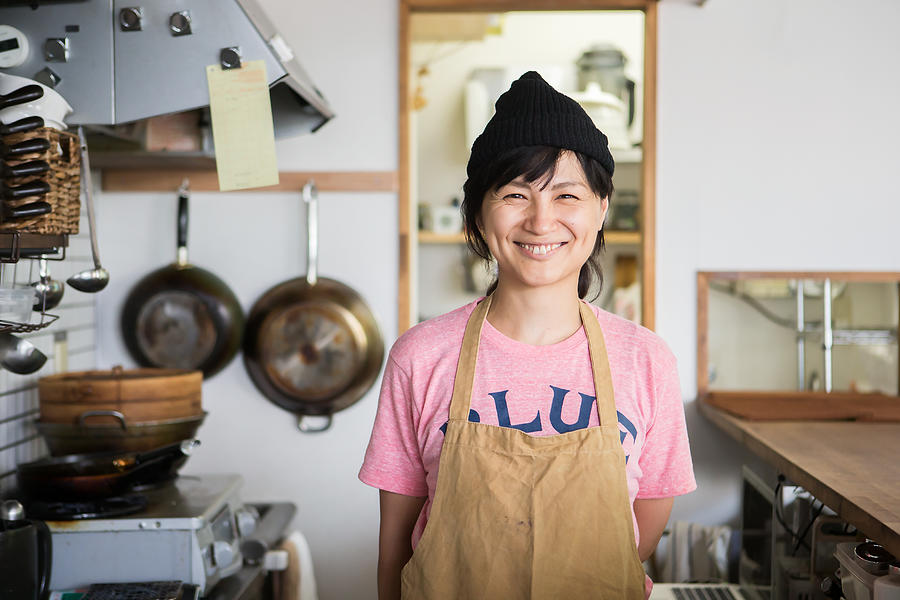 A woman owner who shows a proud smile in the kitchen Photograph by Taiyou Nomachi