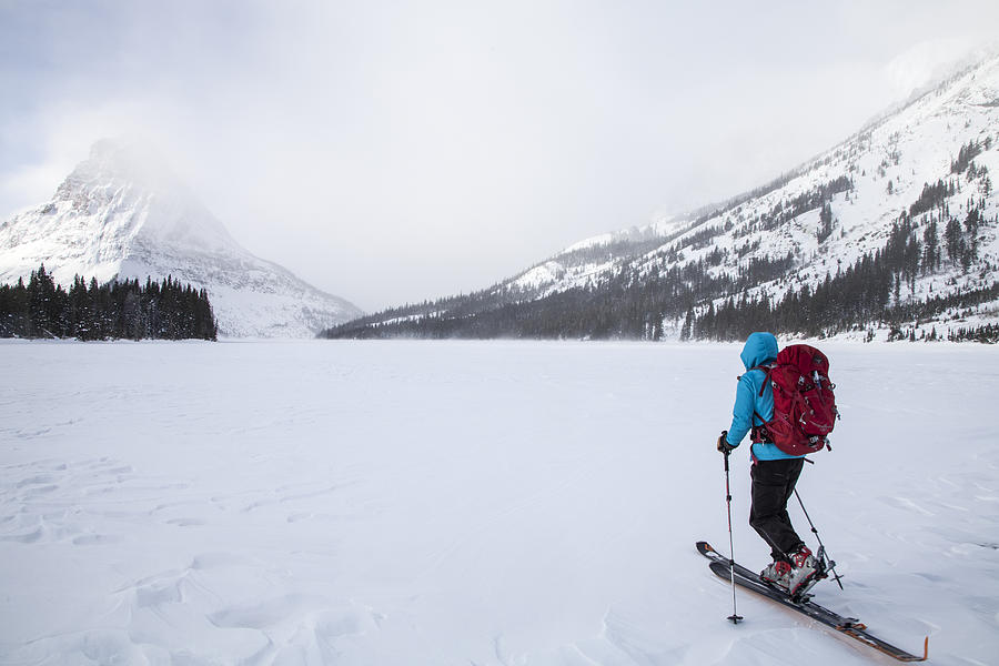 A woman skiing on Two Medicine Lake in front of Sinopah Mountain in Glacier National Park, Montana. Photograph by Robin Carleton