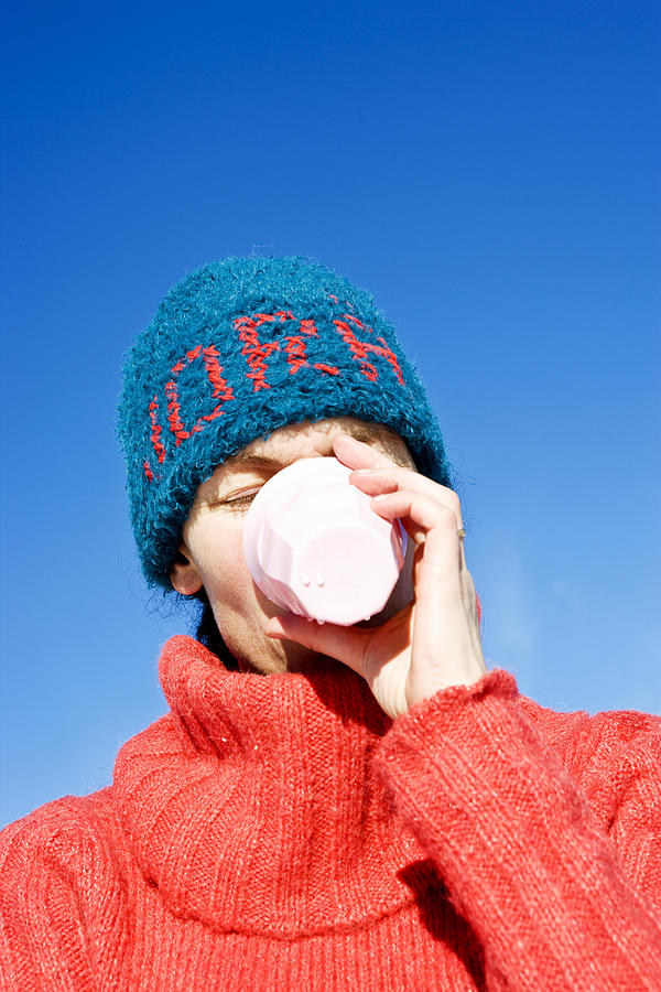 A woman with a blue hat drinking from a cup Sweden. Photograph by Ulf Huett Nilsson A woman with a blue hat drinking from a cup Sweden. Photograph by Ulf Huett Nilsson