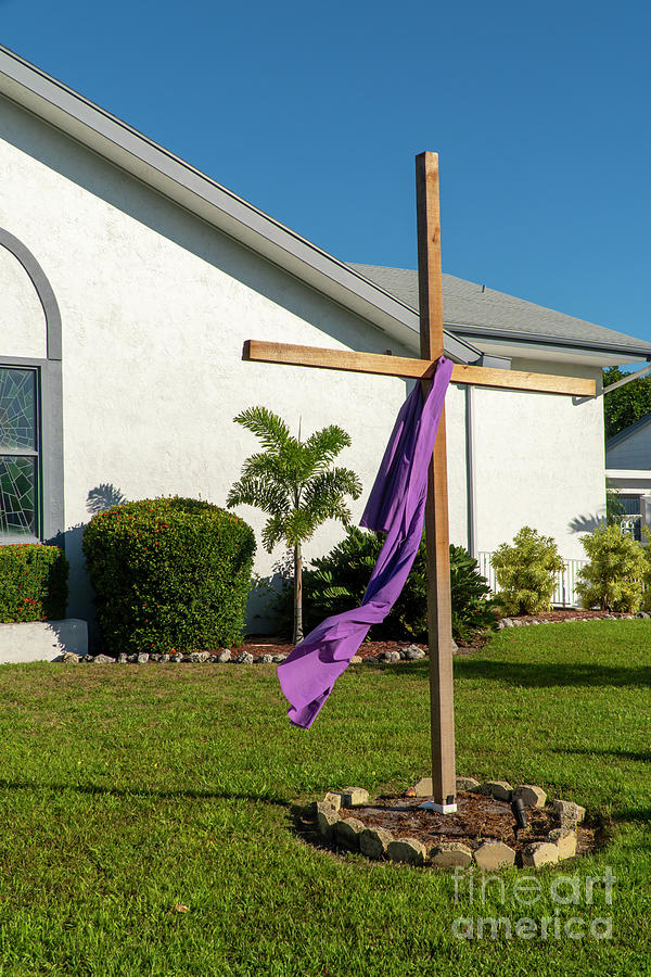 A wooden cross is draped with purple cloth during Easter week on Photograph by William Kuta