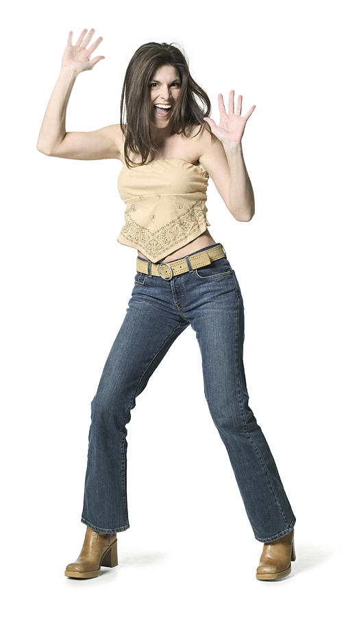 A Young Adult Female In Jeans And A Tan Shirt Dances Around And Holds Up Her Arms Photograph by Photodisc