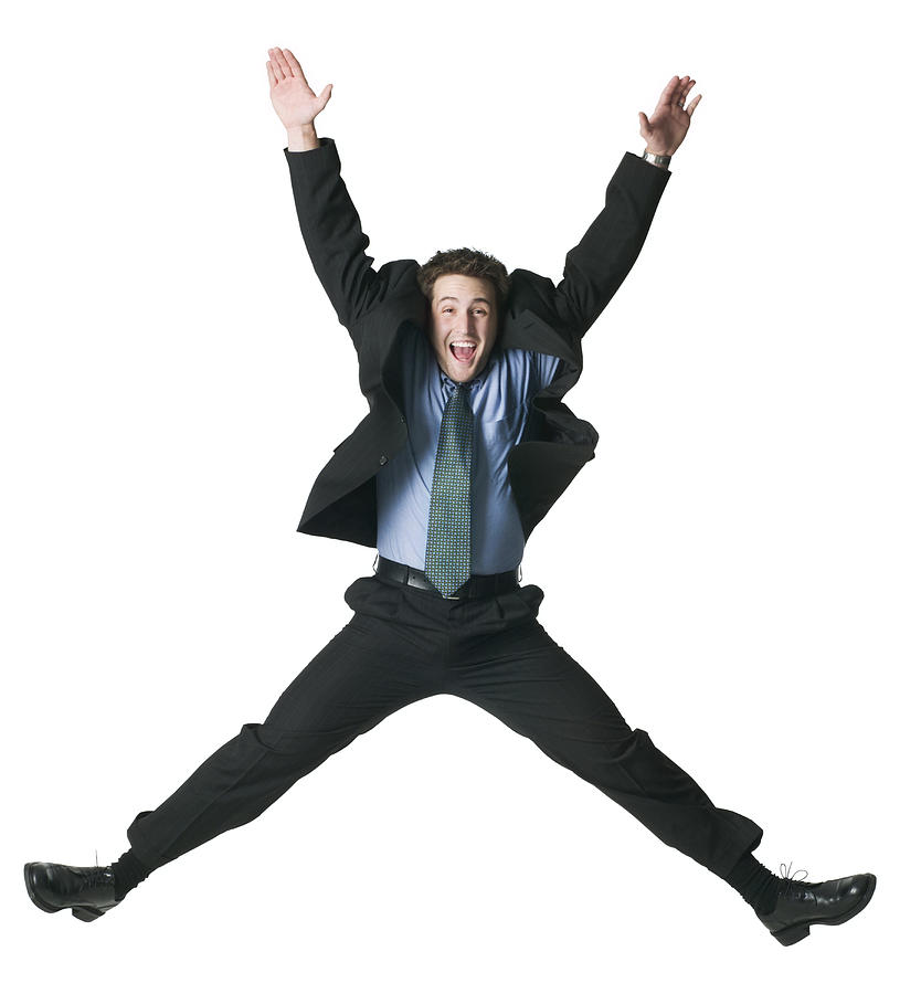 A Young Adult Male In A Business Suit Jumps Up Wildly Into The Air Photograph by Photodisc