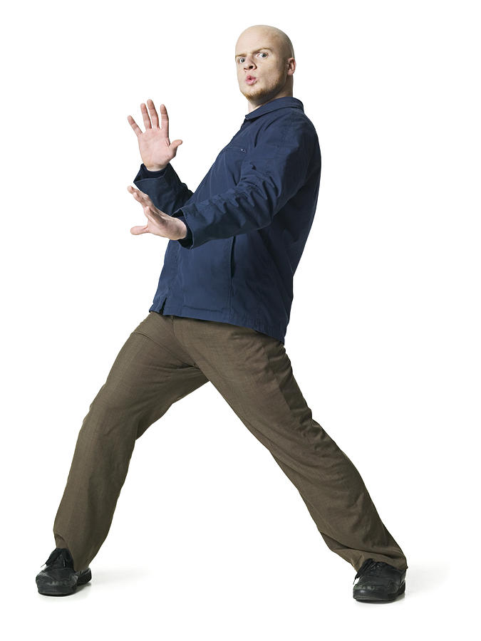 A Young Adult Male In Brown Pants And A Blue Jacket Dances Around Playfully Photograph by Photodisc