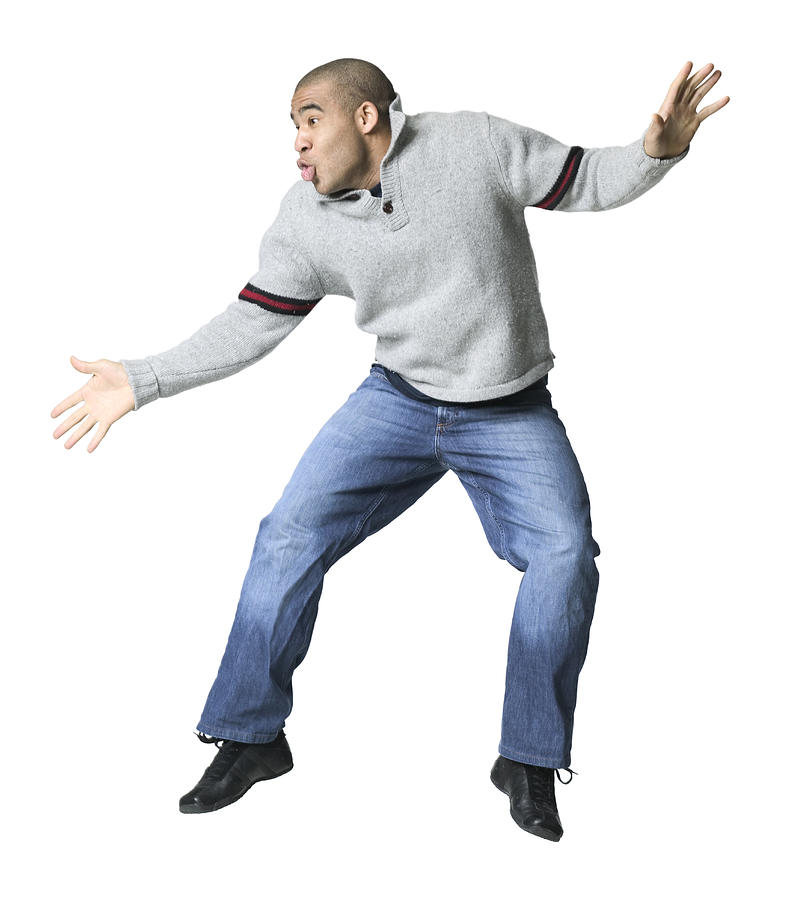 A Young Adult Male In Jeans And A Grey Shirt Sweater As He Does A Silly Dance Photograph by Photodisc