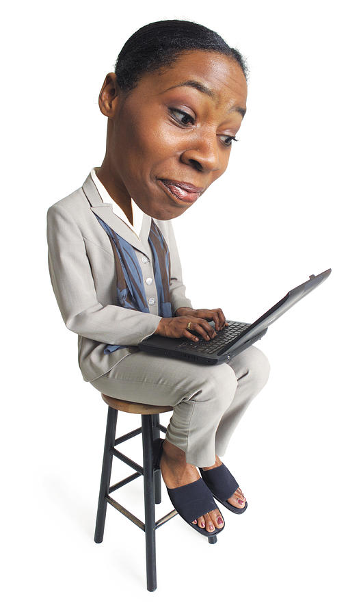 A Young African American Business Woman Sits With A Computer On Her Lap And Types Away Photograph by Photodisc