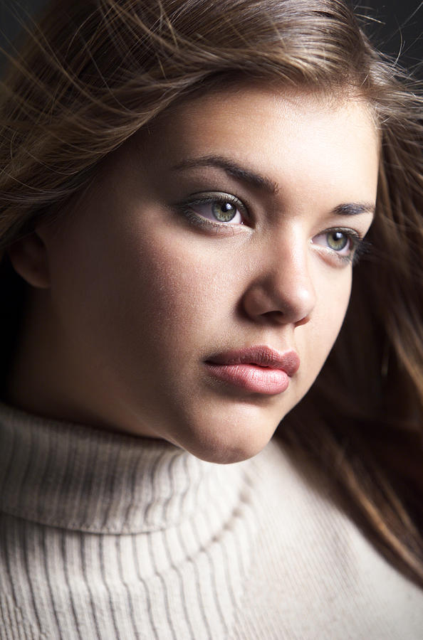 A Young Attractive Caucasian Female In A Tan Turtle Neck Sweater Looks To The Side Photograph by Digital Vision
