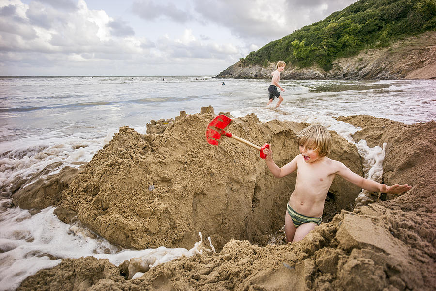A young boy digging in the sand on holiday. Photograph by Roy JAMES Shakespeare