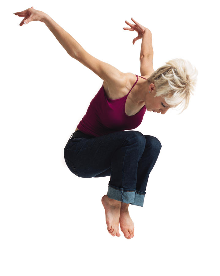 A Young Caucasian Blonde Female In Jeans And A Purple Tank Top Leaps Into The Air And Throws Her Arms Up Behind Her Photograph by Photodisc