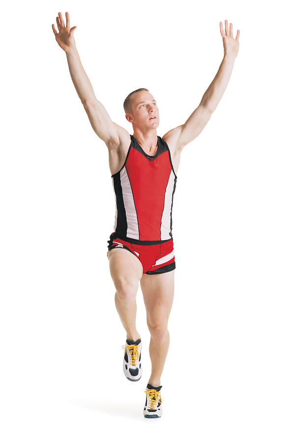 A Young Caucasian Man In A Red Track Uniform Is Running With Arms Raised Overhead In A Victory Lap Photograph by Photodisc