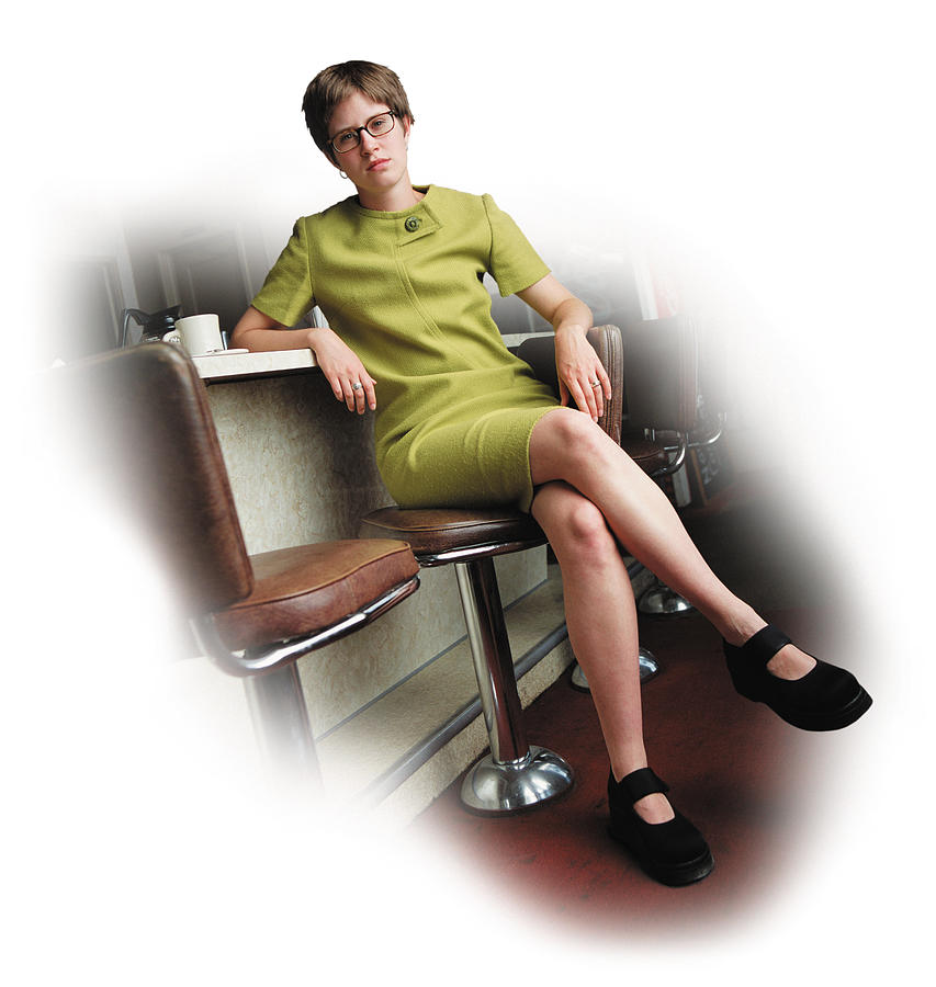 A Young Caucasian Woman With A Short Trendy Green Dress And Glasses Is Sitting At The Bar Of A Diner Looking Seriously At The Camera Photograph by Photodisc