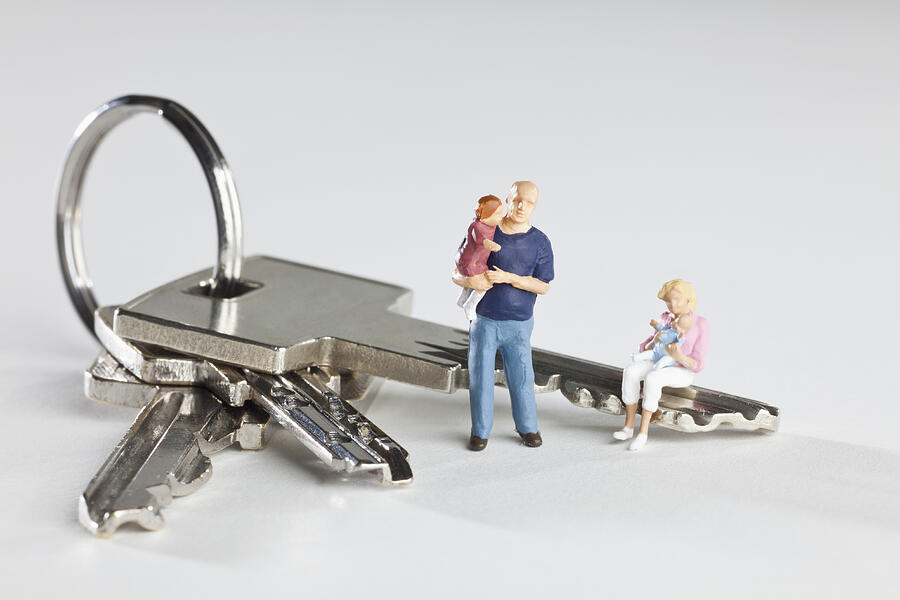 A young family of miniature figurines and house keys on a key ring Photograph by Caspar Benson