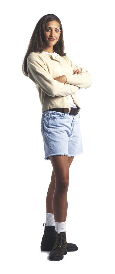 A Young Female Teen In A Tan Sweater And Shorts Folds Her Arms And Smiles Photograph by Photodisc