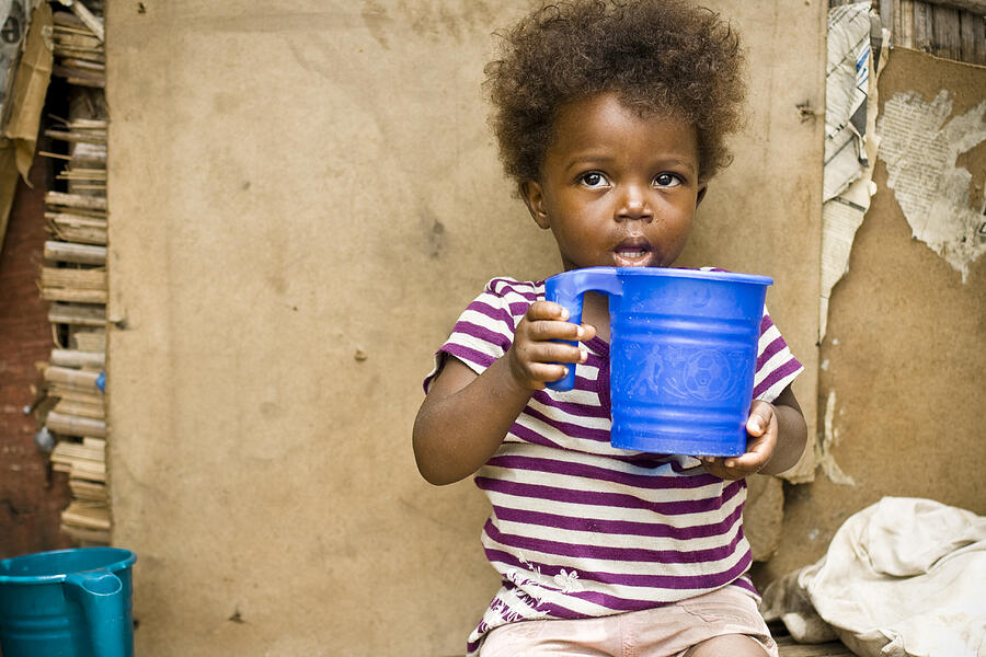 A young girl in Africa holding a blue bucket Photograph by Himarkley