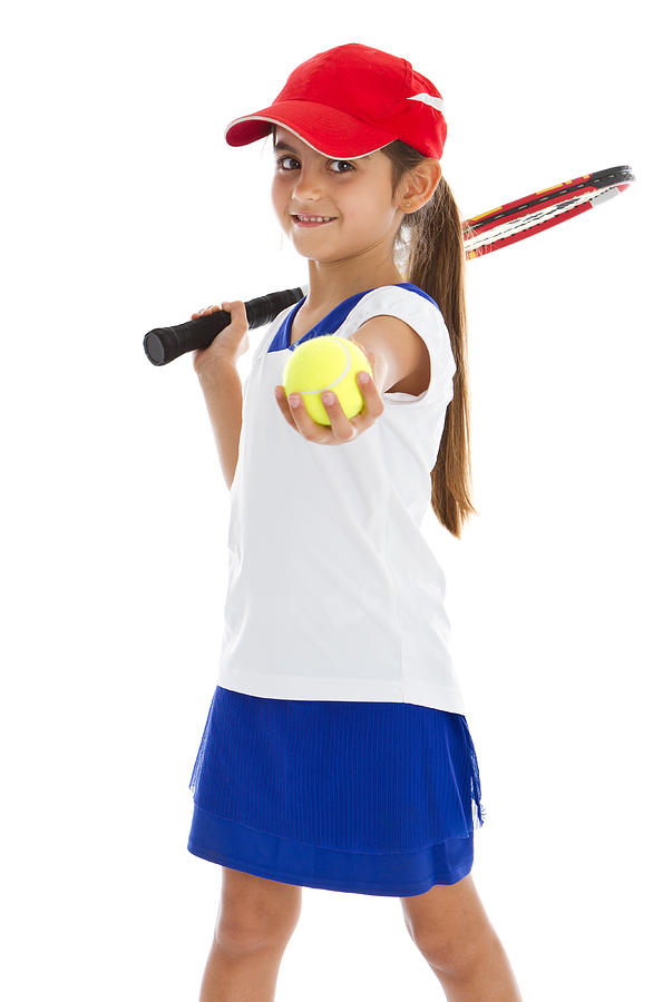 A young girl with a tennis racket holding out a tennis ball Photograph by Ruizluquepaz
