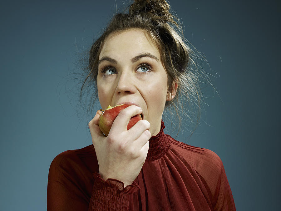 A young hip woman eating an apple Photograph by fStop Images - Carl Smith