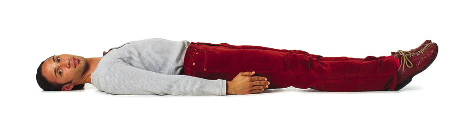 A Young Hispanic Male In Colorful Clothes Lays Down To Create A Hyphen With His Body Photograph by Photodisc
