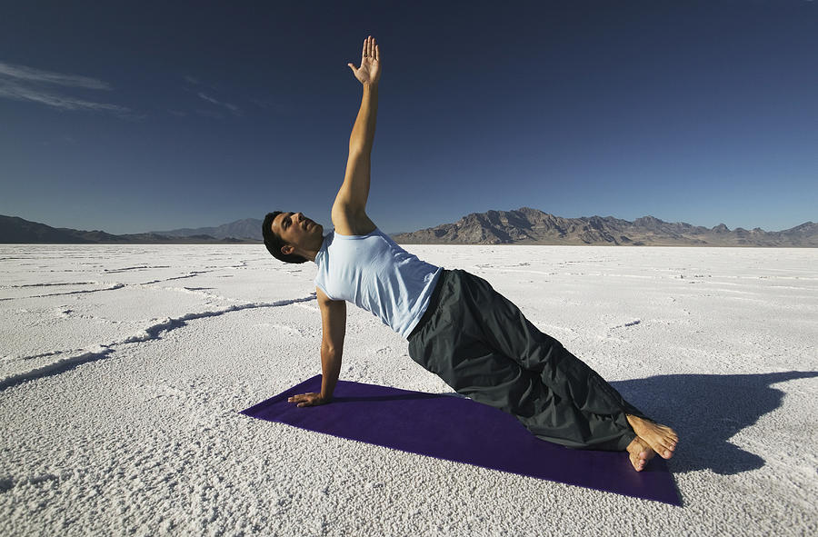 A Young Hispanic Man Practices Stretching And Yoga In A Desert Setting Photograph by Photodisc