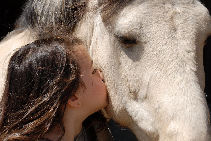 A young lady kissing a horse on the side of the head Photograph by Maxlevoyou
