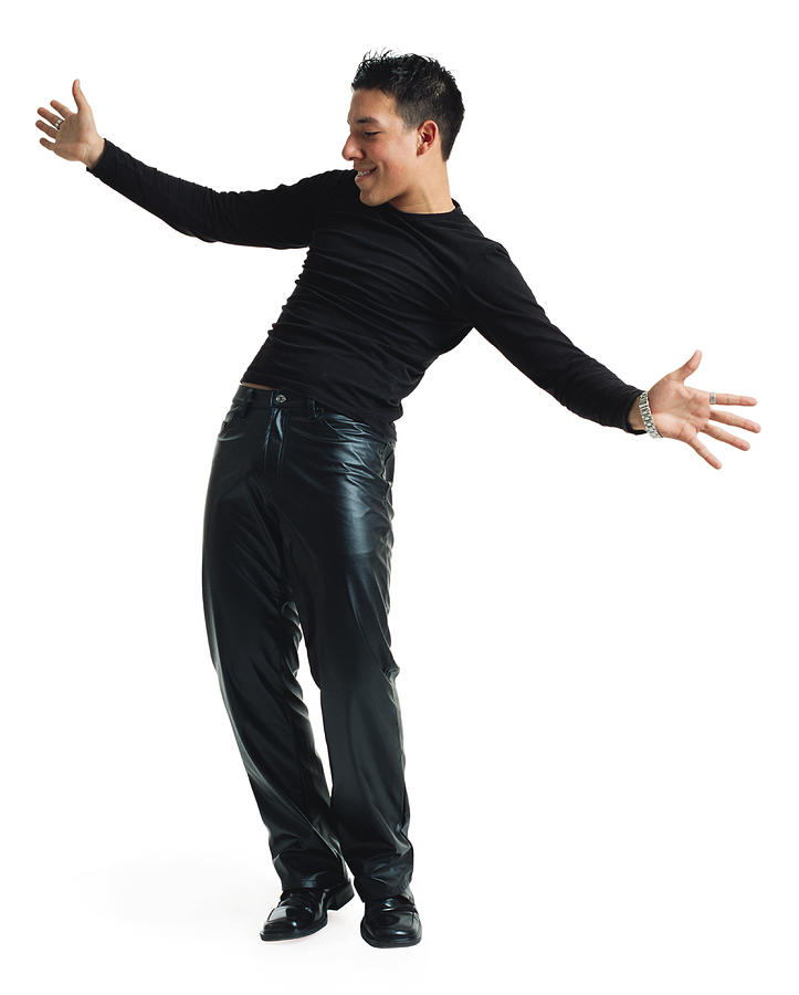 A Young Latin Male Dancer In Black Leather Pants And A Black Shirt Leans His Body Back And Playfully Stretches Out His Arms As He Smiles Photograph by Photodisc