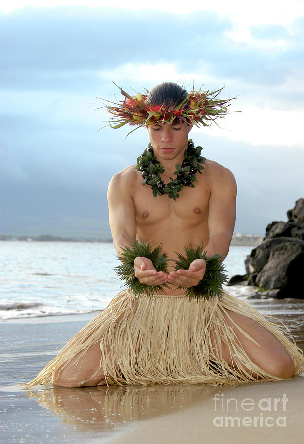 A young male hula dancer gestures giving in a hula dance. Photograph by Gunther Allen