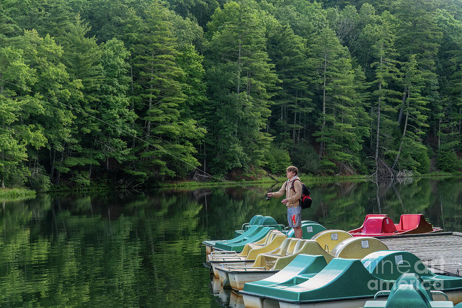 A young man fishes at Watoga Lake in Watoga State Park, Marlinto Photograph by William Kuta