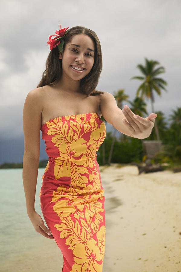 A Young Polynesian Woman In A Floral Dress Dances While On A Beach Photograph by Photodisc