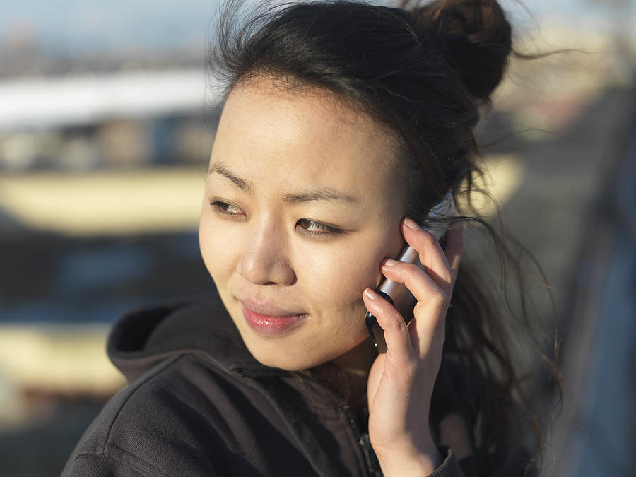 A young woman uses her phone to make a call. Photograph by xPACIFICA