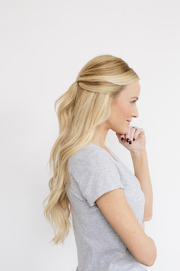 A young woman with long blond wavy hair. Side view. Photograph by Mint Images