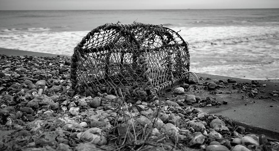 Abandoned lobster pot on the beach in black and white Photograph by Chris Yaxley