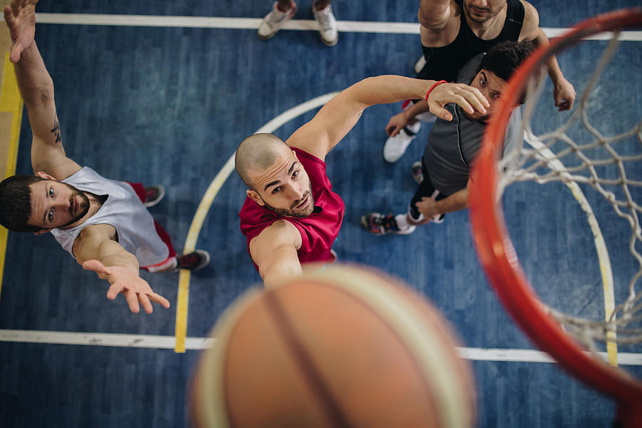 Above view of determined basketball players in action. Photograph by Skynesher