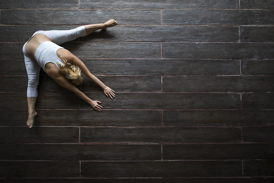 Above view of woman doing relaxation exercises on wooden floor. Photograph by BraunS