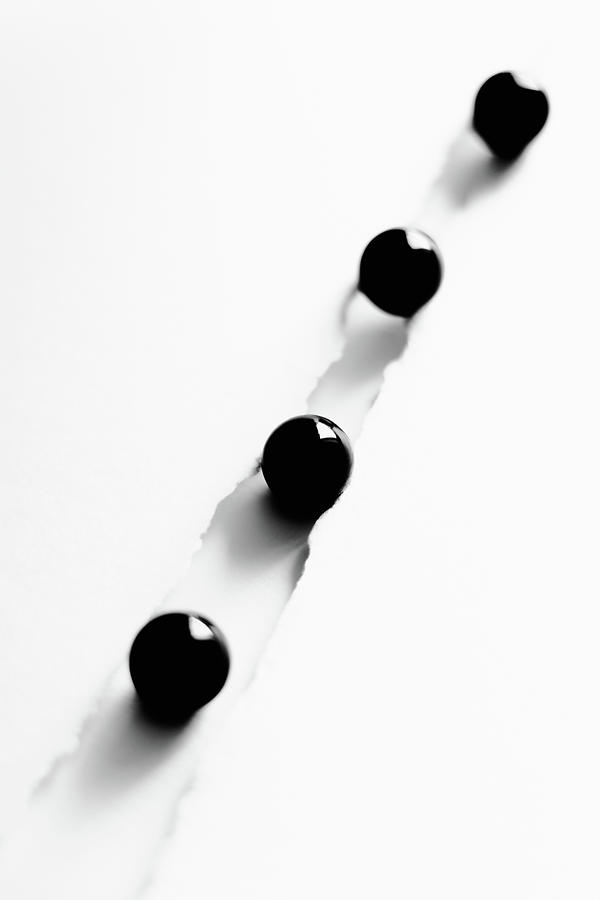 Abstract minimalist illustration with four black marbles in a fl Photograph by Cristina Stefan