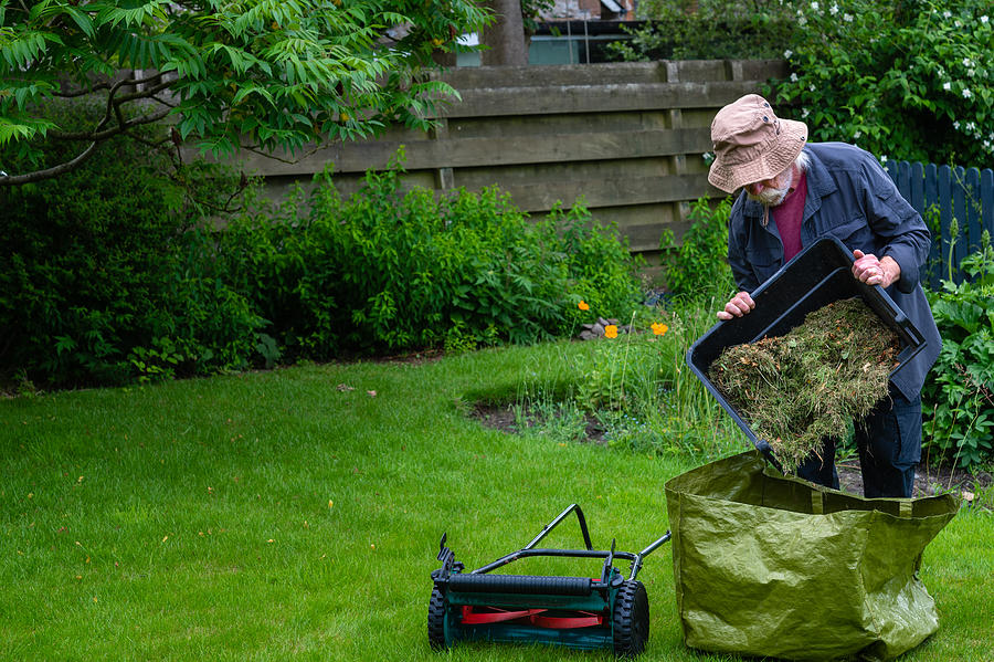 Active retired man emptying a grass box Photograph by JohnFScott