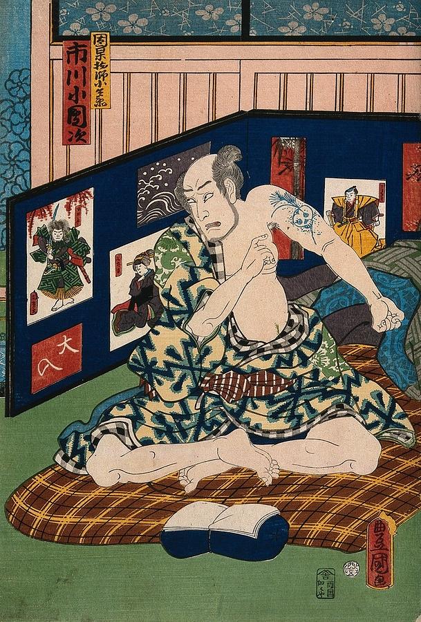 Actor Ichikawa Kodanji seated on bedding revealing a tattoo of a skull amid grasses on his left arm. Painting by Artistic Rifki