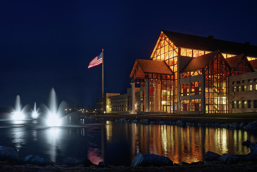 Acuity at Night - Acuity Insurance with giant flag and reflecting pond at night in Sheboygan WI Photograph by Peter Herman