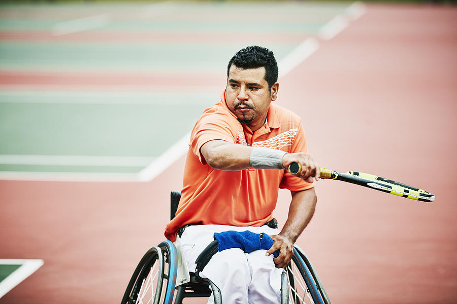 Adaptive athlete preparing for backhand shot during wheelchair tennis match Photograph by Thomas Barwick