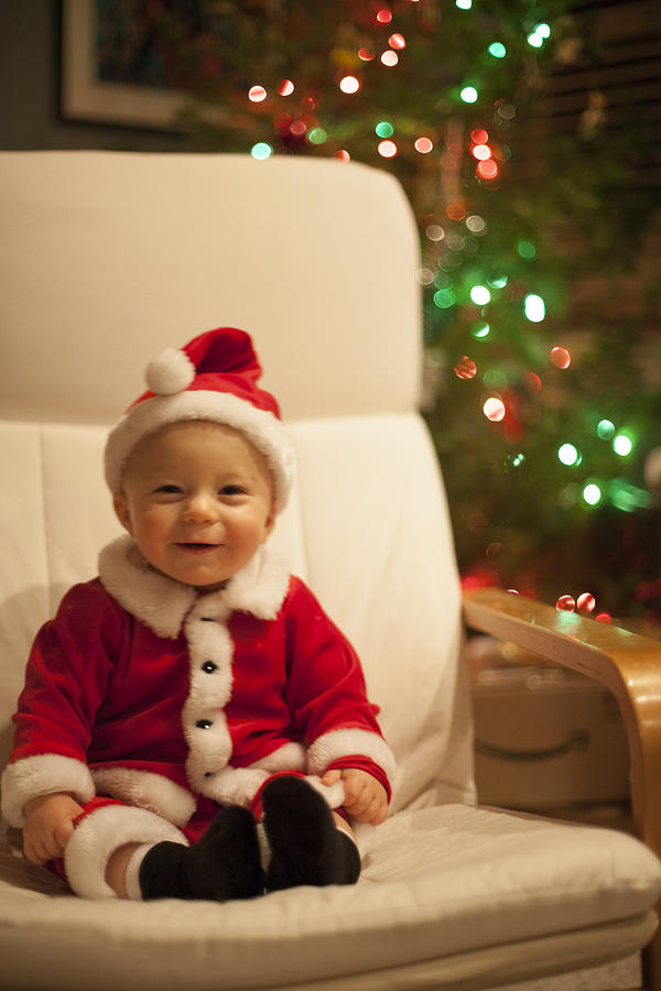 Adorable baby boy wearing santa outfit smiles. Photograph by Heath Korvola