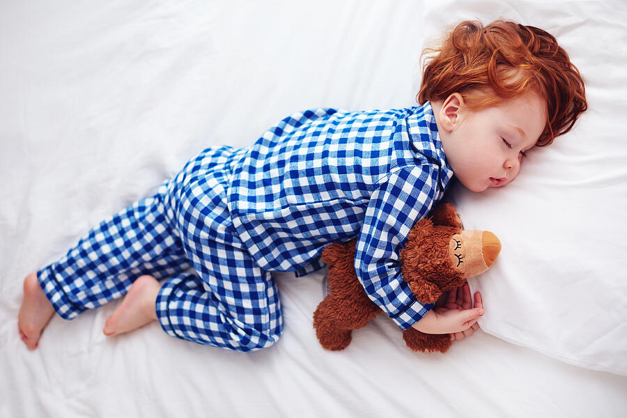 Adorable Redhead Toddler Baby Sleeping With Plush Toy In Flannel Pajamas Photograph by Olesiabilkei