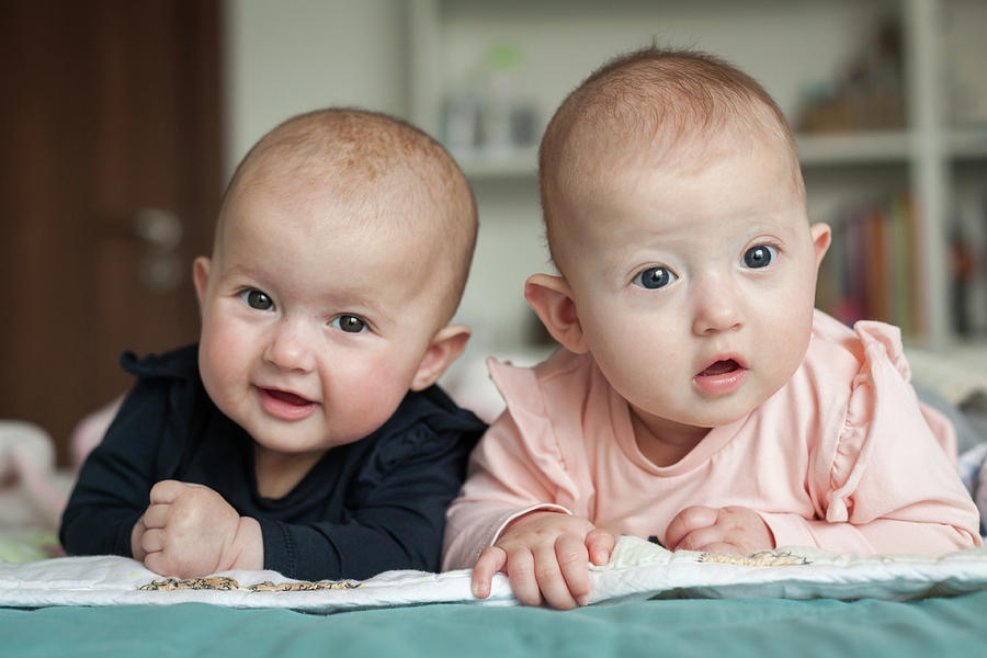 Adorable Six Months Old Baby Twins In Bed At Home. Cute Kids During Tummy Time. Two Baby Twins On Bed. Photograph