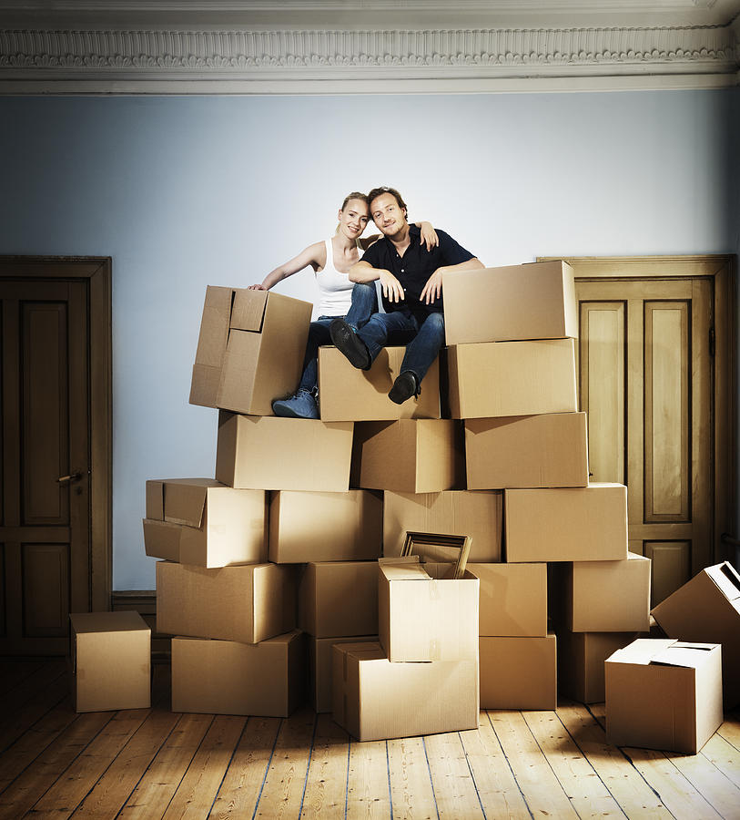 Adult couple sitting on top of moving crates mount Photograph by Henrik Sorensen