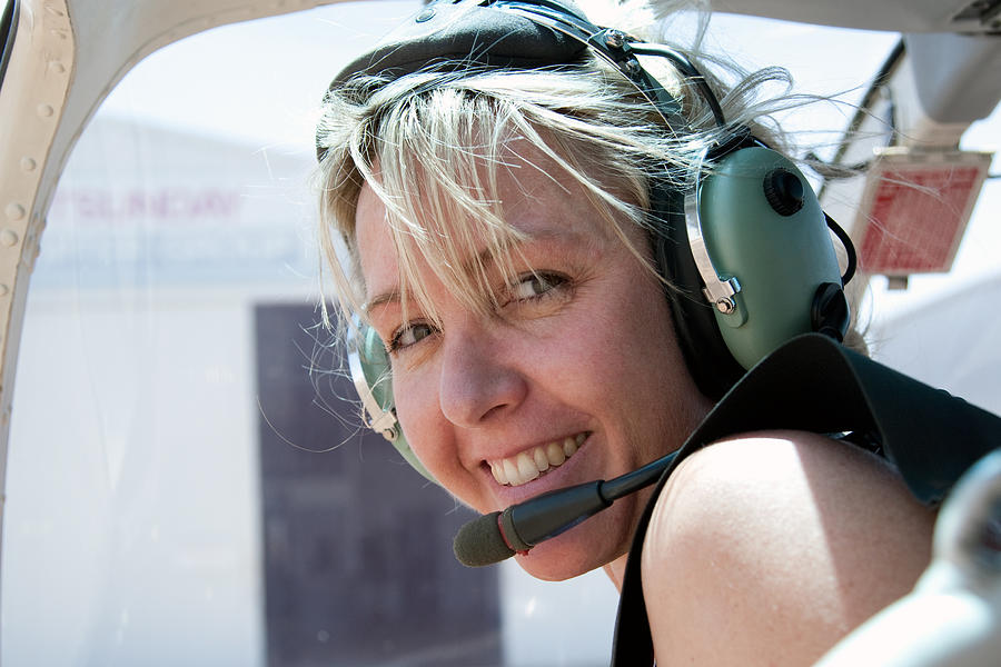 Adventurous Woman in Helicopter wearing headset Photograph by Pamspix