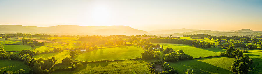 Aerial panorama over idyllic rural landscape golden sunset green pasture Photograph by fotoVoyager