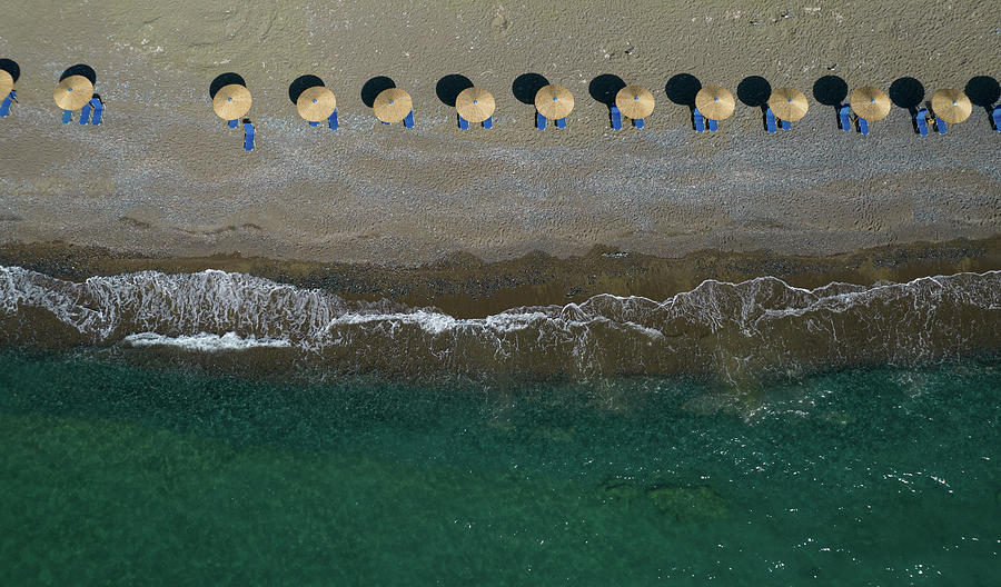 Aerial View From A Flying Drone Of Beach Umbrellas In A Row On An Empty Beach With Braking Waves. Photograph