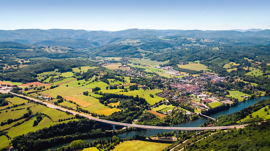 Aerial view of beautiful french countryside with elevated highway small village and beginning of Alps mountains in background Photograph by Gregory_DUBUS