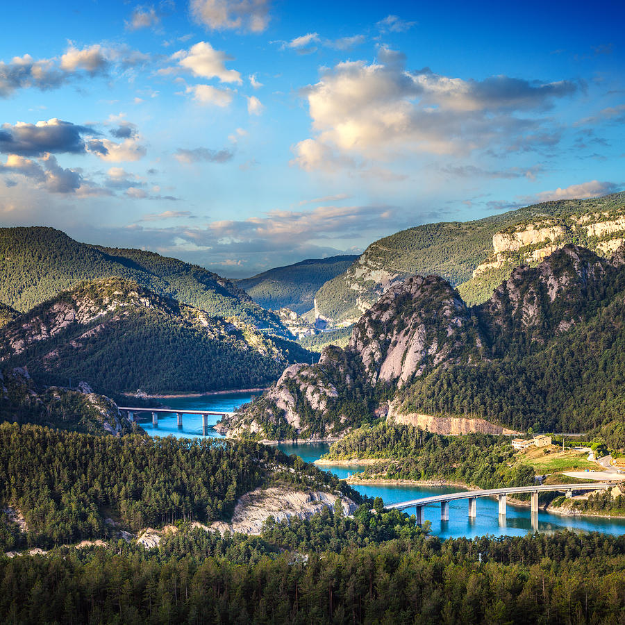 Aerial view of beautiful turquoise lake in mountains and bridges across it. Photograph by Sankai